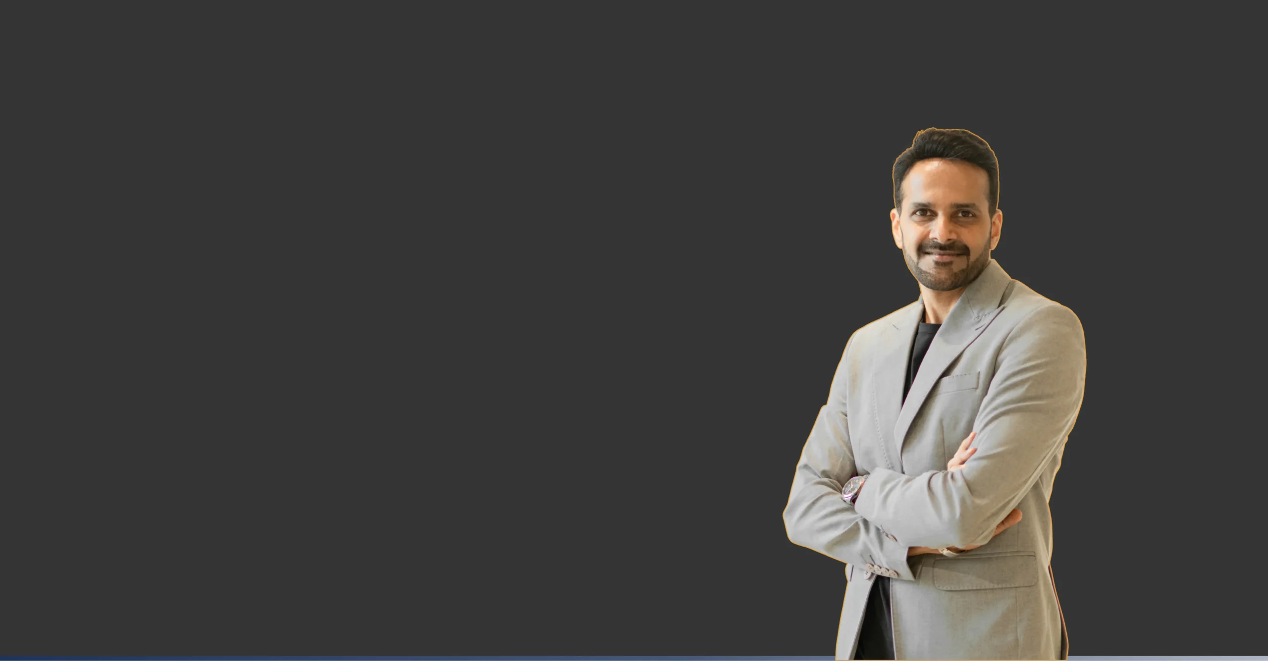 Coach Vijay in a light grey blazer with his arms crossed
